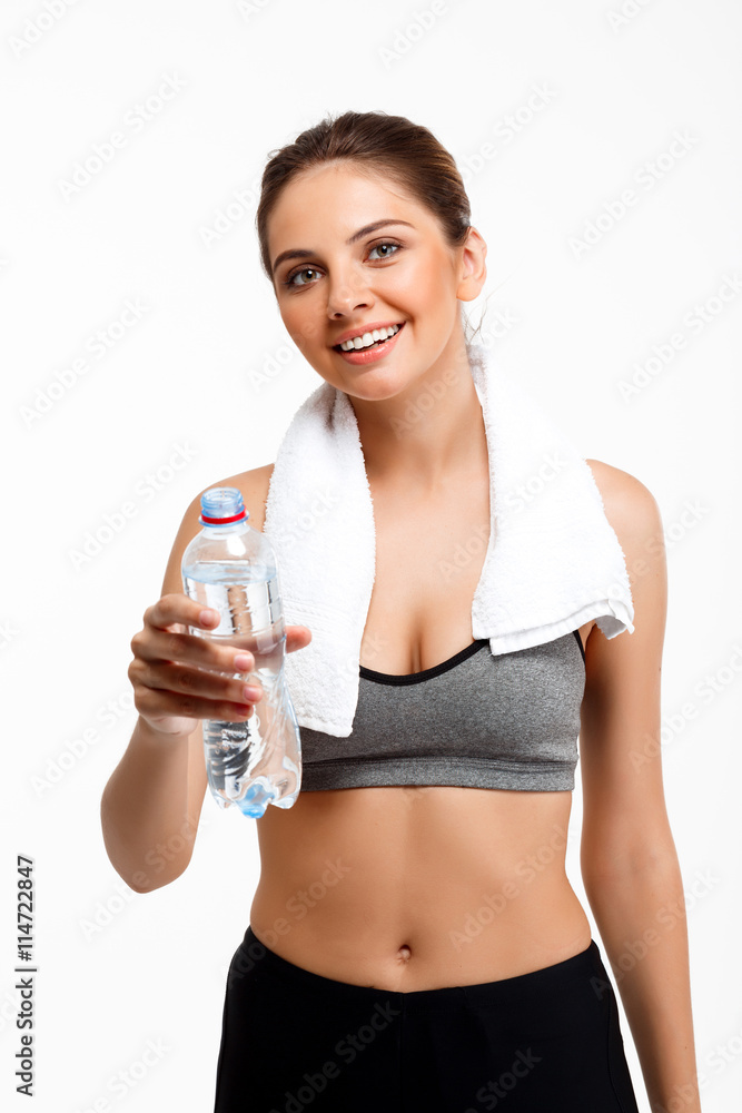 Portrait of young beautiful sportive girl over white background. Drinking water Portrait of young beautiful sportive girl over white background. Drinking water
