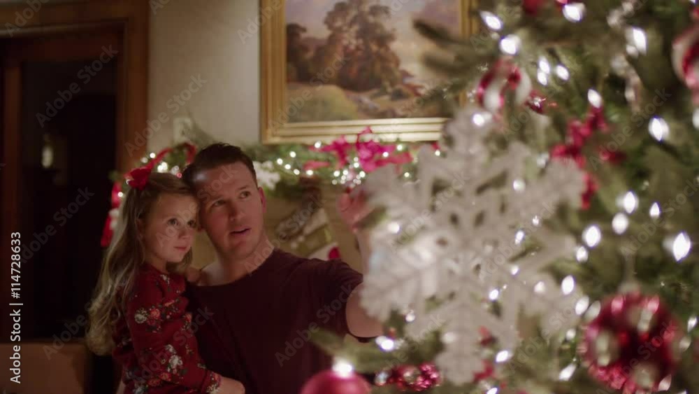 Medium shot of father and daughter admiring Christmas tree / Cedar Hills, Utah, United States Medium shot of father and daughter admiring Christmas tree / Cedar Hills, Utah, United States