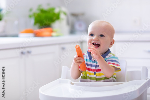 Little baby eating carrot