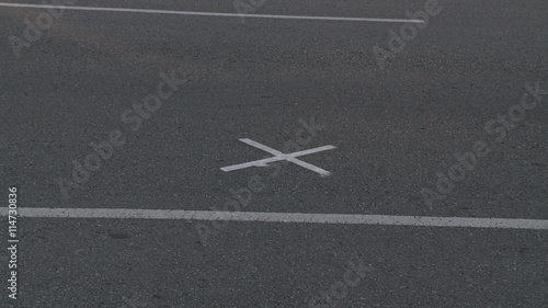 Zoom-in to white X on gray pavement photo