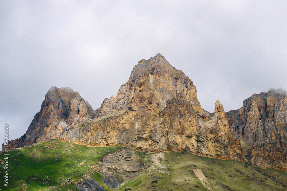 The mountains in the Caucasus. Rock. The mountainous landscape. Mountains, meadow. Mountain landscape and mountain roads. The tops of the mountains in the clouds. Misty mountains.
