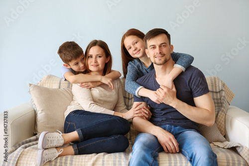 Happy family embracing on sofa