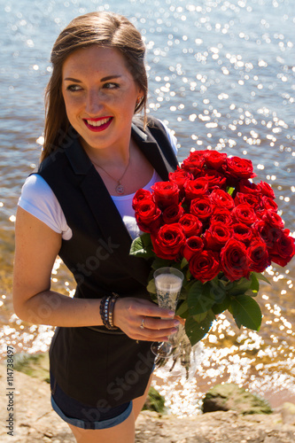 Image of sexy woman posin on sea with glass and roses