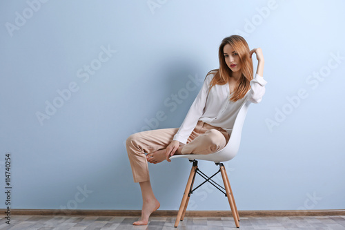 Beautiful young woman sitti...