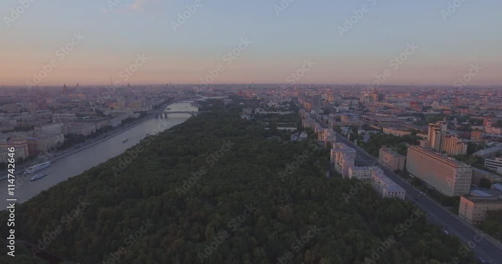 Aerial view of public park, tops of the trees, Moscow River, and city skyline during sunset in Moscow, Russia. Aerial view of public park, tops of the trees, Moscow River, and city skyline during sunset in Moscow, Russia.