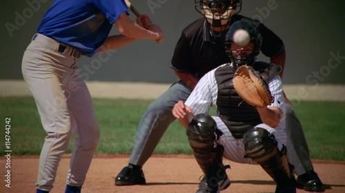 Left-handed batter swinging at ball and missing, slow motion