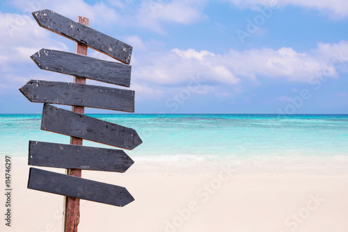 Wood signs on the beach. Sea and blue sky background