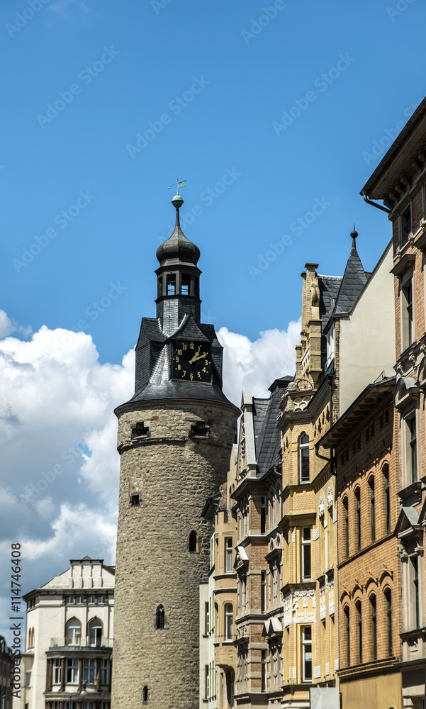 Naklejka premium ancient clock tower in the old city on sky background