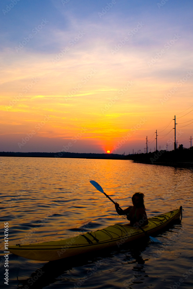 Woman kayaking in the back bay at sunset