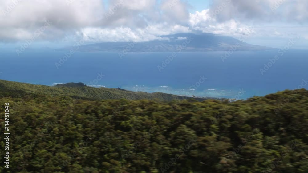 Flying over wooded hilltops on Molokai with Maui in distance. Shot in 2010. Flying over wooded hilltops on Molokai with Maui in distance. Shot in 2010.