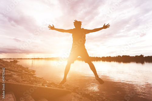 male traveler standing on the river and cloudy sky at early even