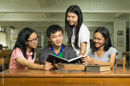 Portrait of a serious young student reading a book in a library