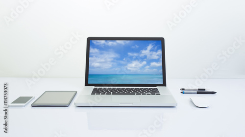 Laptop computer and office accessories on white table