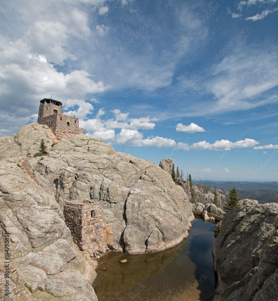 Harney Peak Fire Lookout Tower and pump house with small dam under expansive cirrus cloudscape in Custer State Park in the Black Hills of South Dakota USA
