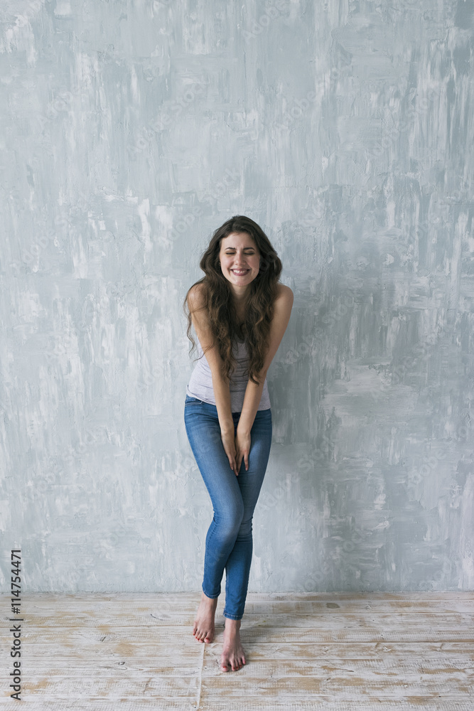 Fototapeta premium Studio shot of smiling shy brunette with squinting eyes