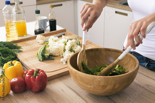 Foto Woman preparing healthy salad in kitchen