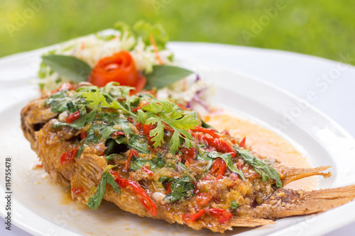 Deep fried red tilapia topped with sweet and sour sauce on top,