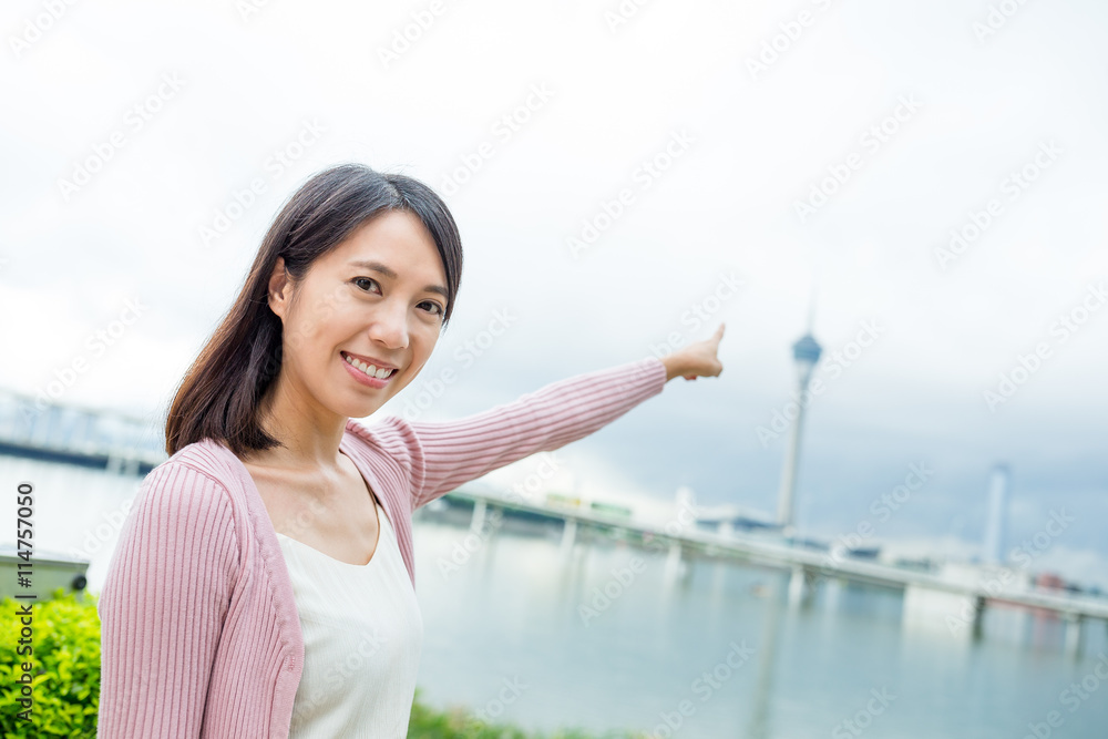 Woman finger pointing to the Macau tower Woman finger pointing to the Macau tower
