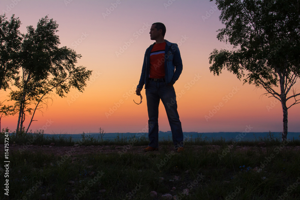 Sunrise. The man sits on the mountain at sunrise. Восход солнца. Мужчина сидит на горе на восходе солнца.

