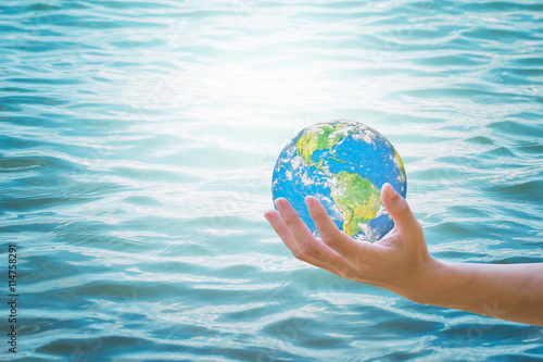 Human hands both sides holding world.Background blur pure water From nature. Environment Day concept.Ecology concept.Environment Day concept.Ecology concept.Elements of this image furnished by NASA.