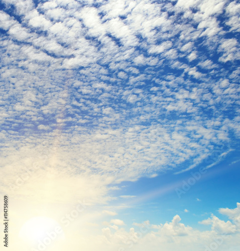 sun on blue sky with white clouds