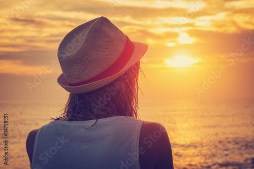 Girl watching the sunset/sunrise over sea.
