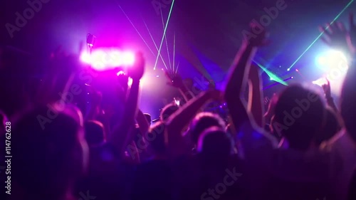 Crowd making party at a rock concert. People dancing at party in club photo