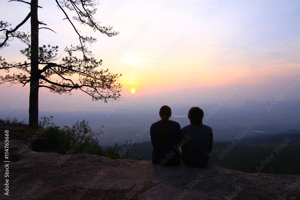 Couple in evening light with mountain and mist on background.