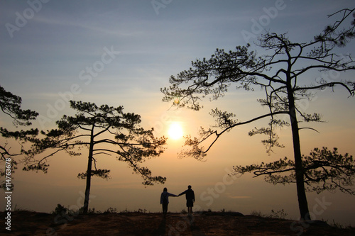 Couple in evening light with mountain and mist on background.