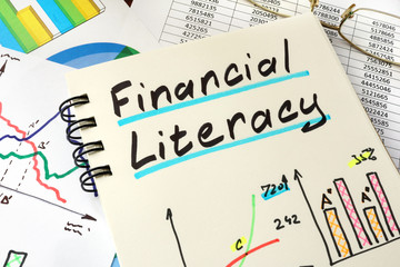 Financial Literacy written on a notepad sheet.  