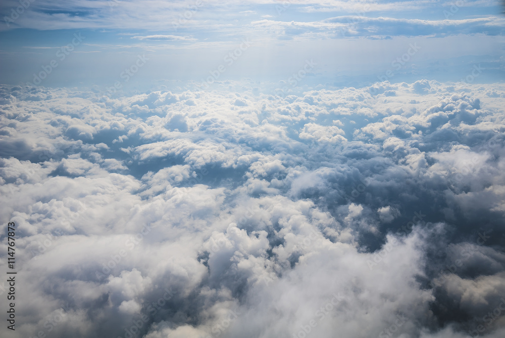 Clouds, sun and sky as seen in window of an aircraft