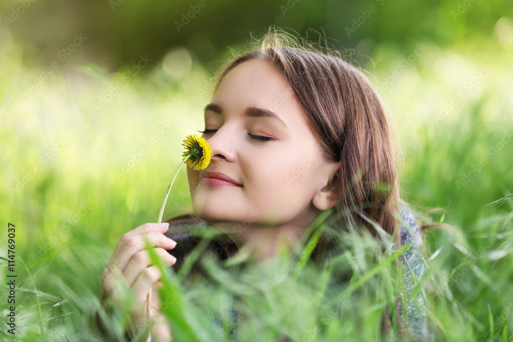 Young beautiful girl laying on green grass Young beautiful girl laying on green grass