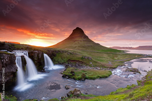 Amazing sunset the top of Kirkjufellsfoss waterfall with Kirkjufell mountain in the background on the north coast of Iceland's Snaefellsnes peninsula taken white a long shutter speed. © Menno Schaefer