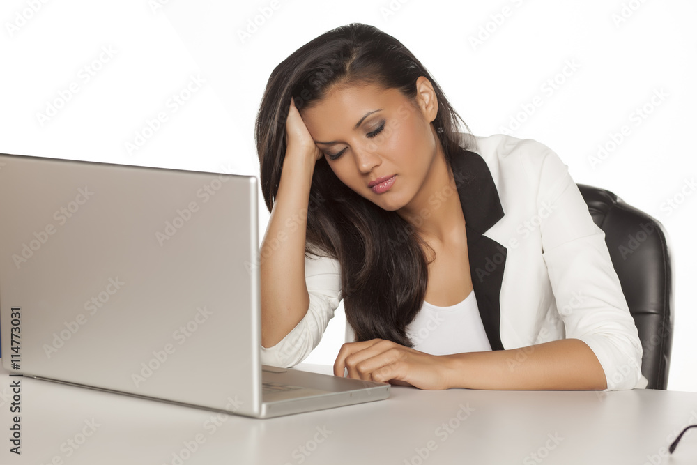 young tired business woman taking a nap on a desk with a laptop young tired business woman taking a nap on a desk with a laptop