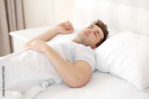 Young man sleeping on comfortable bed