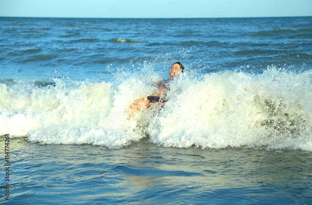 happy boy plays by jumping the waves of the sea happy boy plays by jumping the waves of the sea