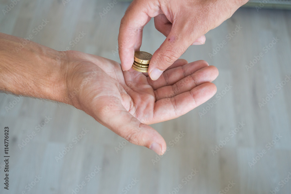 Man giving coins to another person Man giving coins to another person