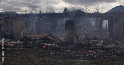 Wide view of smoldering rubble in the ruins of a burned house