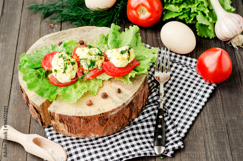 snacks , fresh tomatoes stuffed with eggs, melted cheese , mayonnaise and garlic with dill and lettuce on a wooden background snacks , fresh tomatoes stuffed with eggs, melted cheese , mayonnaise and garlic with dill and lettuce on a wooden background