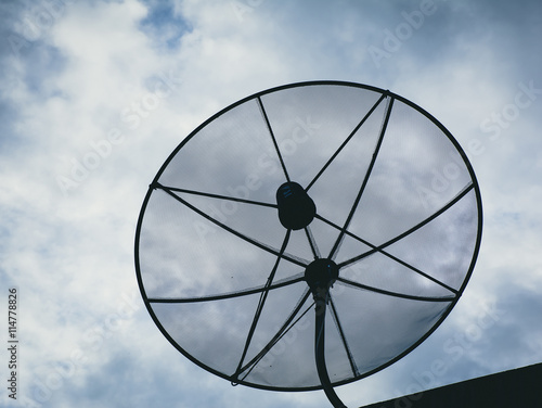 Close up of Satellite dish with fluffy clouds in blue tone background