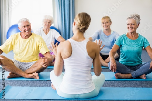 Instructor performing yoga with seniors