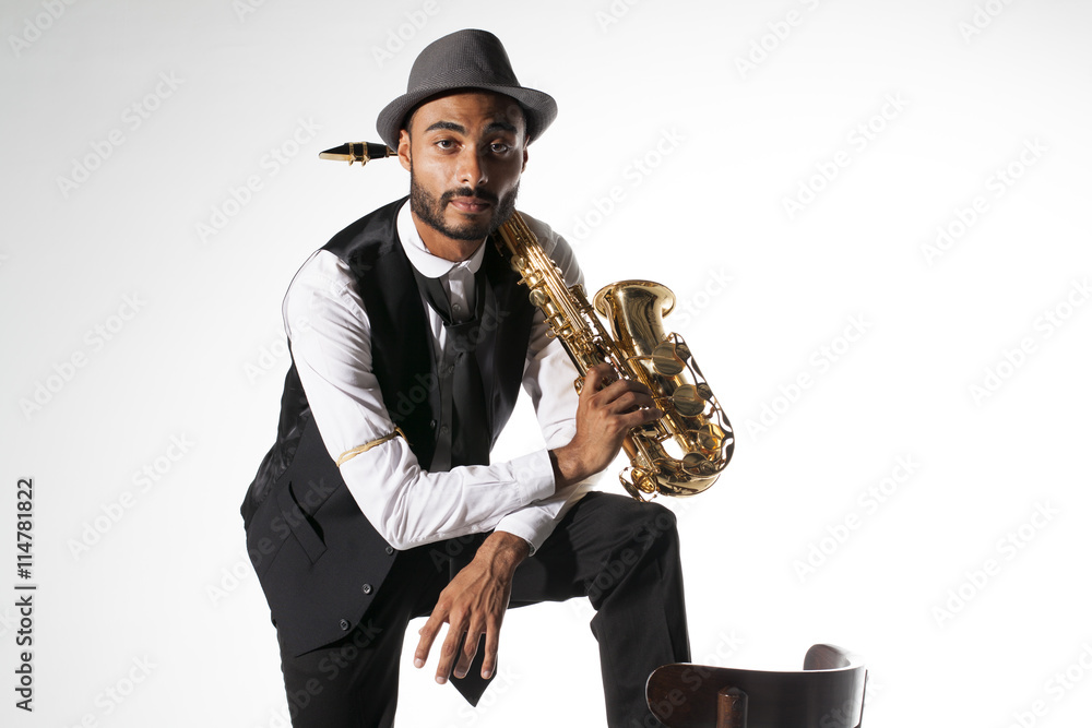 Fototapeta premium Saxofonista apoyando un pie en silla vintage