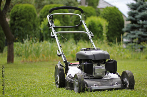 Obraz na plátně Lawn mower in the garden after mowing grass, powerful petrol lawn mower
