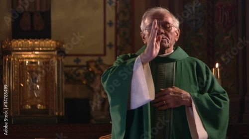 Close view of priest giving benediction and dismissing congregants