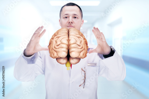 Doctor with stethoscope and brains on the hands in a hospital. High resolution.