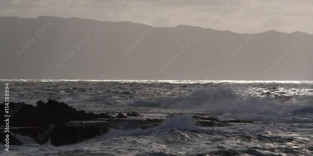 Foaming waves exploding close to the camera on a rocky reef Foaming waves exploding close to the camera on a rocky reef