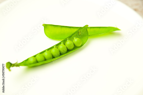 Green pea pod on the  big white plate.