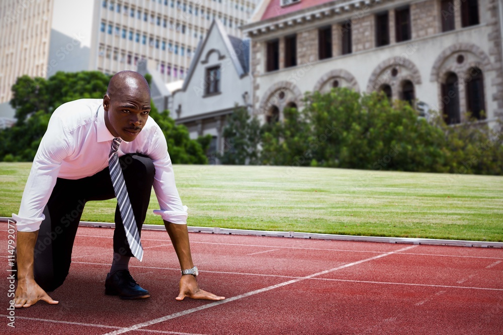 Fototapeta premium Composite image of close up of businessman in starting blocks