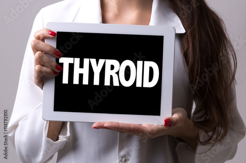 Female doctor holding a tablet with the text: Thyroid