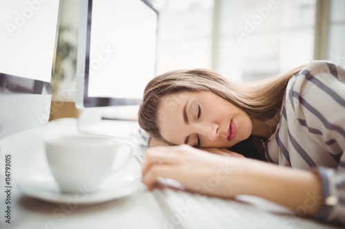 Tired businesswoman taking nap in creative office